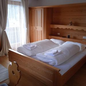 uma cama com toalhas brancas com uma janela em Apartement Noggler Zimmer mit Frühstück em Malles Venosta