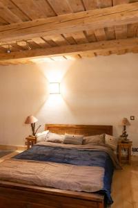 a bedroom with a large bed in a room with wooden ceilings at Gîte ferme en permaculture avec ses animaux in Sixt