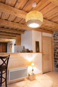 een kamer met een tafel en een plafond met een licht bij Gîte ferme en permaculture avec ses animaux in Sixt