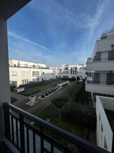 a balcony with a view of a street with buildings at LOTUS- 4 min de Walt Disney-Arrivée autonome-Parking et Wifi gratuit-Proche de toutes commodités 5Min de la vallée village in Chessy