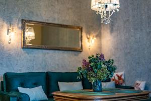 ein Esszimmer mit einem Tisch und einer Vase aus Blumen in der Unterkunft Zielony Apartament Pod Żaglami in Zegrze Południowe