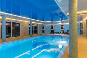 a large swimming pool in a building with a building at Zielony Apartament Pod Żaglami in Zegrze Południowe