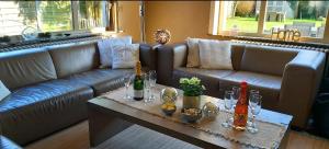a living room with a couch and a table with wine bottles at Vakantievilla Het Dunehuys in De Panne