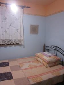 a small bedroom with a bed and a window at Apartments Radnić in Pag