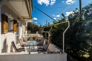 a patio with a table and chairs on a balcony at Sunny Sofi Studios in Plános