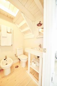 een witte badkamer met een toilet en een wastafel bij Casa El Tejo in El Tejo