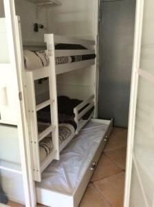 a closet with four bunk beds in a room at Cap Agde Studio-Cabine jardin clos, port et plage in Cap d'Agde