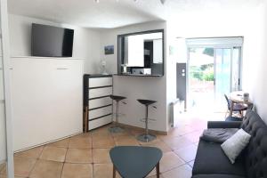 a living room with a couch and a mirror at Cap Agde Studio-Cabine jardin clos, port et plage in Cap d'Agde