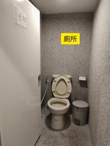 a bathroom with a toilet and a sign on the wall at Beer Inn綠島 in Green Island