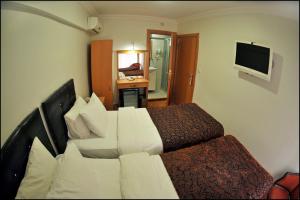 a hotel room with two beds and a television at Palace Point Hotel in Istanbul