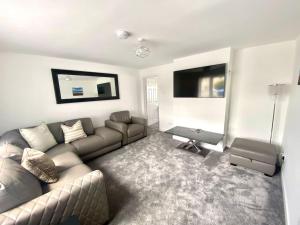 a living room with a couch and a table at The Hoot Luxury home close to town and beaches in Pembrokeshire