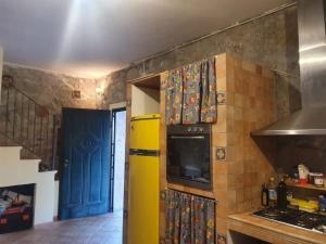a kitchen with a yellow refrigerator and a blue door at Casa di Nonna Luciana 