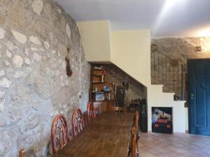 a dining room with a wooden table and a stone wall at Casa di Nonna Luciana 