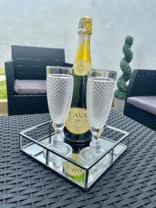 a bottle of champagne and two glasses on a table at The Hoot Luxury home close to town and beaches in Pembrokeshire