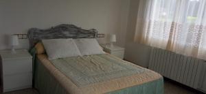 a bedroom with a bed with a wooden headboard at Vacaciones en A Costa da Morte in Buño