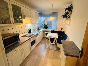 a kitchen with white cabinets and a table and a counter at Ferienwohnung am alten Weinberg in Bad Berleburg