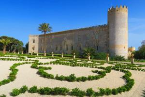 een tuin voor een kasteel met een toren bij Casa Vacanze Marina di Ragusa Apt Il Gufo in Marina di Ragusa