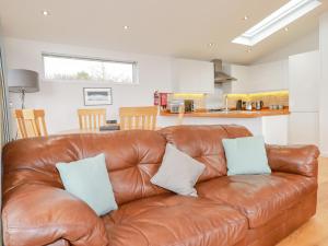 a brown leather couch in a living room at 10 Faraway Fields in Liskeard