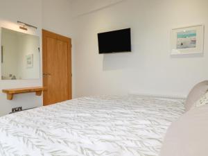 a bedroom with a bed and a television on the wall at 10 Faraway Fields in Liskeard