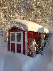 un pequeño edificio rojo con nieve encima en Bergruhe en Sankt Ruprecht ob Murau