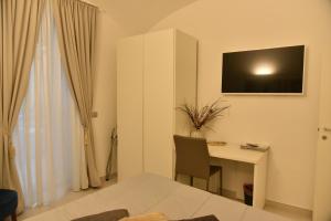 a white room with a desk and a table with a computer at Conte Max Rooms in Termoli