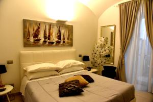a bedroom with a large white bed with a painting on the wall at Conte Max Rooms in Termoli