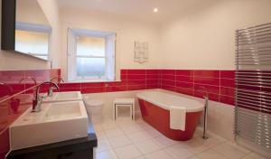 库珀Cherry Blossom Cottage的带浴缸、水槽和红色瓷砖的浴室 更多12张照片