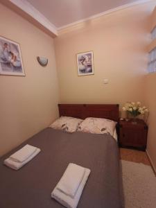 a bedroom with a bed with two towels on it at Apartament Spacerowa z balkonem in Kołobrzeg