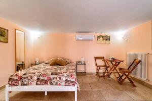 1 dormitorio con 1 cama, mesa y sillas en L' ATTICO CastroSalento, en Castro di Lecce