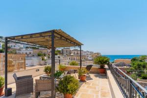 a patio with chairs and plants on a roof at L' ATTICO CastroSalento in Castro di Lecce