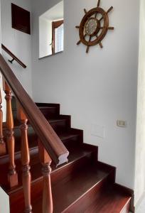 a wooden staircase with a clock on the wall at Aeolian Apartments in Lipari