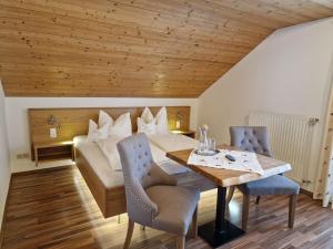 a room with a bed and a table and chairs at Bio-Bauernhof Vordergrubenbach - Familie Oberascher in Hintersee