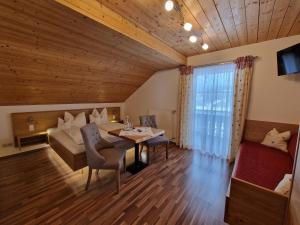 1 dormitorio y sala de estar con mesa y 1 cama. en Bio-Bauernhof Vordergrubenbach - Familie Oberascher, en Hintersee