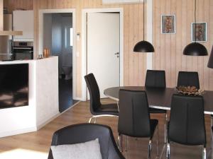 亨能史特蘭德的住宿－8 person holiday home in Henne，一间带桌子和黑色椅子的用餐室
