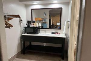 a bathroom with a sink and a mirror at Super 8 by Wyndham Mont Belvieu - Baytown East in Eldon +30 photos