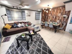 un soggiorno con divano e tavolo di Melaka-Private Pool/19pax Vacation Home/BBQ a Paya Rumput