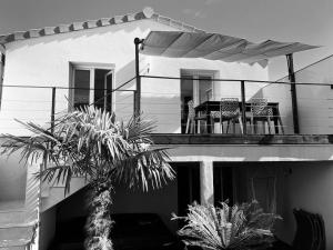 d'un balcon avec une table et des chaises. dans l'établissement Les Palmiers. Charme, spa et massage en vignoble nantais, au Pallet