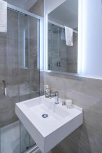 a bathroom with a white sink and a shower at Correnti Boutique Hotel Gold in Sanremo