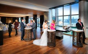 a bride and groom standing at a bar at their wedding at Hyatt Regency Köln in Cologne
