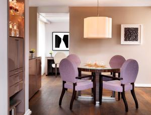 uma sala de jantar com uma mesa e cadeiras roxas em Hyatt Regency Köln em Colônia