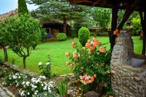 um jardim com flores e uma parede de pedra em Дядо Петковата Къща em Elena