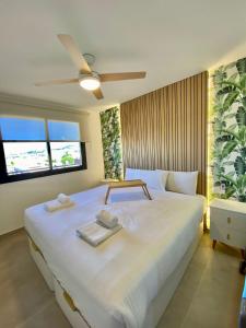 a bedroom with a large white bed with two towels on it at Chill in paradise in Playa Paraiso