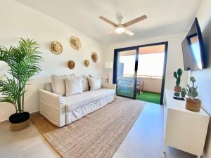 un soggiorno con divano bianco e ventilatore a soffitto di Chill in paradise a Playa Paraiso