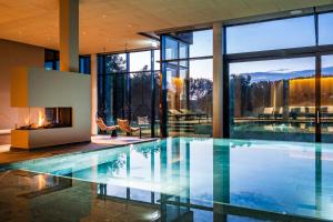 an indoor swimming pool with a fireplace in a house at Hotel Breitenburg in Breitenburg