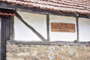 a sign on a window of a stone building at Дядо Петковата Къща in Elena