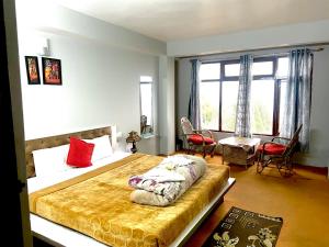 a bedroom with a large bed with red pillows at Hotel Snow Valley Rooftop in Pelling