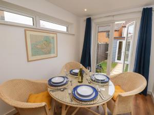 a dining room with a table and chairs and a window at Sandy Cottage in Sandown