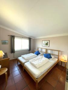 - une chambre avec un grand lit blanc et des oreillers bleus dans l'établissement Vakantiewoning direct aan het Veerse Meer, à Kortgene