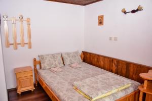 a bedroom with a wooden bed with two pillows at Дядо Петковата Къща in Elena