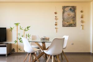 comedor con mesa y sillas blancas en ApartUP Patacona Orchard Views, en Valencia